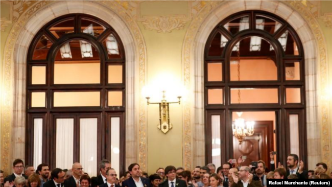 El presidente catalán, Carles Puigdemont, es aplaudido durante una ceremonia dentro del Parlamento regional tras a declaración de independencia de España, en Barcelona.