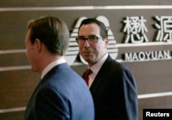 FILE - U.S. Treasury Secretary Steven Mnuchin, right, is seen as he and a U.S. delegation for trade talks with China arrive at a hotel in Beijing, China, May 3, 2018.
