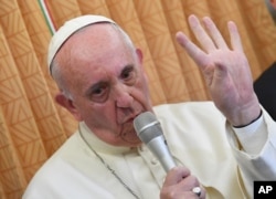 FILE - Pope Francis speaks with journalists on board a flight from Baku to Rome.