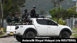 Tentara dan polisi duduk di atas mobil saat berpatroli di Wamena, Papua, 9 Oktober 2019. (Foto: Antara/M.Risyal Hidayat via REUTERS)