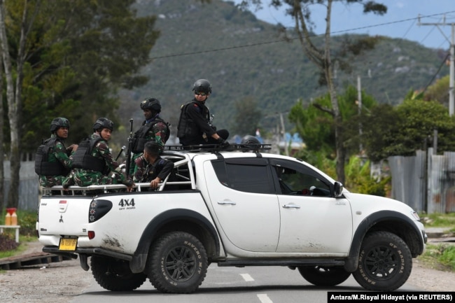 Tentara dan polisi duduk di atas mobil saat berpatroli di Wamena, Papua, 9 Oktober 2019. (Foto: Antara/M.Risyal Hidayat via REUTERS)