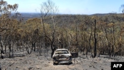 A charred car stands destroyed after a bushfire moved through the area near One Tree Hill in the Adelaide Hills, Jan. 5, 2015. 