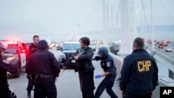 FILE - A California Highway Patrol officer detains a protester on the San Francisco-Oakland Bay Bridge, Jan. 18, 2016, in San Francisco. A group of demonstrators from the group Black Lives Matter caused a shutdown of one side of the bridge in a police brutality protest.