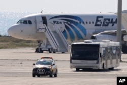 埃及航空公司被劫持的客机3月29日降落在塞浦路斯的拉納卡機場。一辆巴士运载这架班机的一些乘客离开。