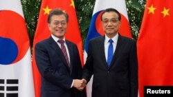 문재인 한국 대통령과 리커창 중국 총리가 15일 베이징 인민대회당에서 만나 악수하고 있다.