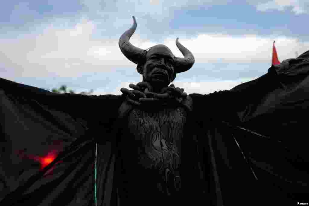 A man dressed as the &quot;Bat King&quot; walks down the street as he takes part in the overnight-into-dawn celebration called J&#39;Ouvert, ahead of the annual West Indian-American Carnival Day Parade in Brooklyn, New York, Sept. 5, 2016.
