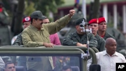 FILE - Defense Minister Vladimir Padrino Lopez, center right, face obscured, and Gen. Ivan Hernández, standing behind Padrino Lopez, head of both the presidential guard and military counterintelligence, accompany Venezuela's President Nicolas Maduro as th