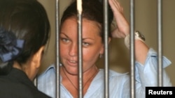 Dalam foto tertanggal 27/1/2005 ini Schapelle Corby, warga Australia yang dijatuhi 20 tahun penjara karena kasus narkoba berbicara dengan pengacaranya sebelum sidang di pengadilan Denpasar, Bali. Setelah mendekam sembilan tahun di penjara, ia dibebaskan bersyarat pada 7 Februari 2014. 