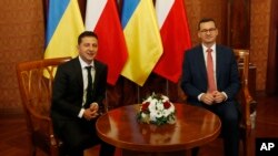 Poland's Prime Minister Mateusz Morawiecki, right, welcomes Ukraine's President Volodymyr Zelenskiy as they meet in Warsaw, Aug. 31, 2019. 