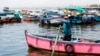 El pescador Máximo Castro apunta hacia el sur, la dirección de donde provino el derrame de petróleo, en su bote en la contaminada bahía de Ancón en Lima, Perú, el viernes 21 de enero de 2022.