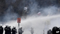 Policija ispaljuje vodene topove tokom protesta protv kovid mera u Briselu (Foto: AP/Geert Vanden Wijngaert)