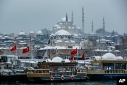 Kapal wisata merapat di Tanduk Emas dengan latar belakang Masjid Suleymaniye di Istanbul, Senin, 24 Januari 2022. (Foto: AP)