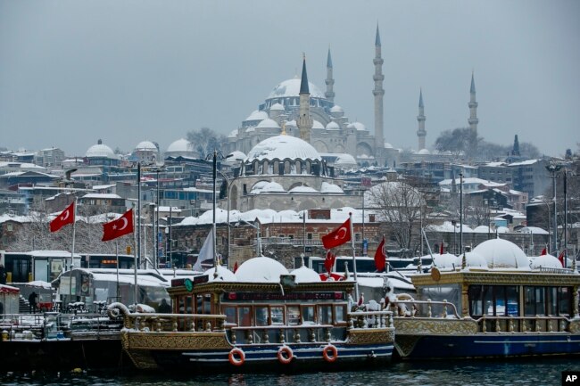 Kapal wisata merapat di Tanduk Emas dengan latar belakang Masjid Suleymaniye di Istanbul, Senin, 24 Januari 2022. (Foto: AP)