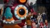 Una pareja con mascarilla para evitar contagios del coronavirus se hace una foto con un tigre robótico colocado como decoración en un centro comercial de Beijing, la víspera del Año Nuevo Lunar, el lunes 31 de enero de 2022.