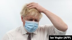 Perdana Menteri Inggris Boris Johnson memberi isyarat saat mengunjungi Finchley Memorial Hospital di London Utara pada 18 Januari 2022. (Foto: AFP)