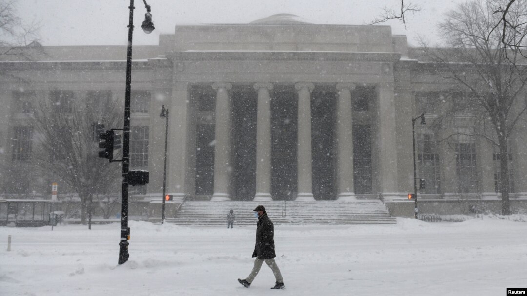 Seorang pejalan kaki melewati salju di luar MIT School of Architecture and Planning selama badai Nor'easter yang kuat di Cambridge, Massachusetts, AS, 29 Januari 2022. (Foto: REUTERS/Nicholas Pfosi)