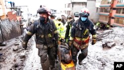 Los equipos de rescate se llevan el cuerpo de una víctima de una inundación repentina provocada por la lluvia que llenó los arroyos cercanos y reventó su mecanismo de contención en el área de La Gasca de Quito, Ecuador, el martes 1 de febrero de 2022.
