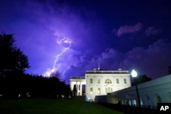 FILE - A bolt of lightning illuminates the clouds of a thunderstorm behind the White House, Tuesday, Aug. 6, 2019, in Washington. (AP Photo/Alex Brandon)
