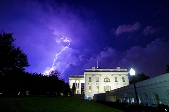 FILE - A bolt of lightning illuminates the clouds of a thunderstorm behind the White House, Tuesday, Aug. 6, 2019, in Washington. (AP Photo/Alex Brandon)