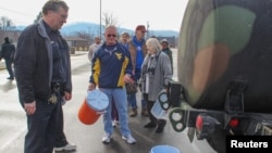 Residentes hacen fila en Virginia Occidental para recibir agua tras la eventual contaminación de las fuentes potables en el estado.