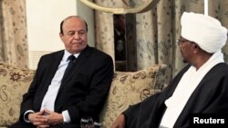 Yemen's President Abd-Rabbu Mansour Hadi interacts with Sudan's President Omar Hassan al-Bashir, right, at Khartoum, Aug. 29, 2015. 