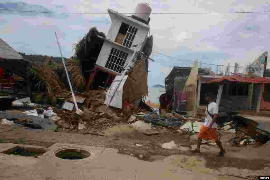 A man walks near a damaged building after the passing of Tropical Storm John in Puerto Marques, Guerrero state, Mexico, Sept. 29, 2024.