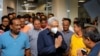 In this handout picture provided by Sri Lanka's Ministry of Urban Development and Housing, the country's former President Gotabaya Rajapaksa, wearing a mask, is greeted upon his arrival at Bandaranaike International airport in Colombo, Sri Lanka, Sept. 3,