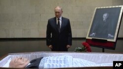 Nan foto sa a ke televizyon Larisi pran Prezidan Vladimir Putin rann yon denye omaj a ansyen lide Sovyetik Mikhail Gorbachev nan Moskou, Larisi. 