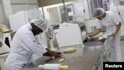 FILE - Edmilson Lourenco, left, who has Down syndrome, works as a baker's assistant in Sao Paulo, March 19, 2015. A new hormone treatment for Down syndrome patients showed some cognitive improvement in the small group it was tested on.