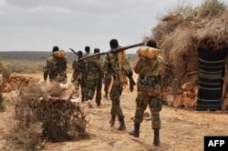 FILE - A handout photo taken June 10, 2016, and released by AMISOM shows soldiers serving under the African Union Mission in Somalia (AMISOM) on foot patrol in Halgan village, Hiran region.