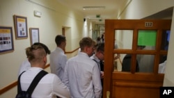 Students enter the classroom at the Limanowski High School in Warsaw, Poland, Sept. 1, 2022.