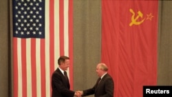 FILE: U.S. President George H. W. Bush (L) and Soviet President Mikhail Gorbachev shake hands in front of U.S. and Soviet flags at the end of the press conference in Moscow in this file image from July 31, 1991.