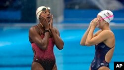 FILE - Simone Manuel of the United States, left, reacts with teammate Katie McLaughlin, at the pool during a swimming training session at the Tokyo Aquatics Center at the 2020 Summer Olympics, July 22, 2021, in Tokyo, Japan.