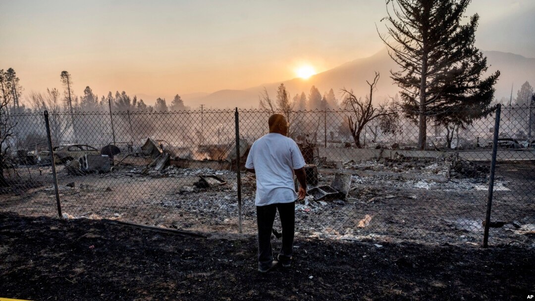 Seorang pria memperhatikan rumahnya yang hancur terbakar oleh kebakaran hutan Mill fire di Weed, California,
Sabtu, 3 September 2022. (Foto: Noah Berger/AP Photo)