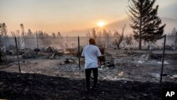 Dave Rodgers surveys his home, destroyed by the Mill Fire, Sept. 3, 2022, in Weed, Calif. Rodgers, who lived in the house his entire life, was able to take an elderly neighbor with him as he fled the fast-moving blaze.