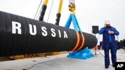 FILE - A Russian worker speaks on a phone during a ceremony marking the start of Nord Stream pipeline construction in Russia, April 9, 2010. Russian energy giant Gazprom said Sept. 2, 2022, it couldn't resume the supply of natural gas to Germany through the pipeline. 