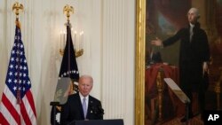 FILE - President Joe Biden speaks before signing an executive order in the East Room of the White House under the portrait of George Washington, May 25, 2022. The Washington portrait has been at the White House since 1800, and was removed to save it from a fire during the War of 1812.