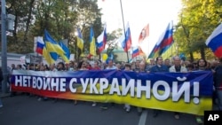 这是在2014年9月21日，俄罗斯示威者手举“不要对乌克兰发动战争”的横幅在莫斯科闹市区抗议游行。成千上万的人加入抗议游行队伍。(美联社资料照）