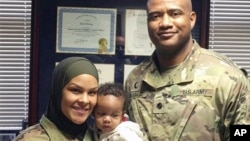 This undated photo provided by Army Col. Khallid Shabazz, right, in January 2022, shows him with with Spc. Savannah Spencer, who requested that Shabazz say a dua prayer for her baby. (Courtesy Khallid Shabazz via AP)