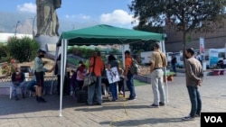 Personas se acercan a un punto de recolección de voluntades en una zona popular en el este de Caracas, el 26 de enero de 2022. [Foto: VOA / Álvaro Algarra].