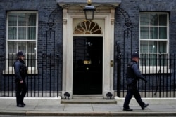 Petugas polisi berjalan melewati 10 Downing Street, kantor PM Inggris di London, Selasa, 25 Januari 2022. (Foto: AFP)