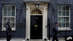 Police officers walk past 10 Downing Street in London, Tuesday, Jan. 25, 2022. London police say they are now investigating Downing Street parties during lockdown. Metropolitan Police Commissioner Cressida Dick revealed an investigation was underway in a statement before the Lond