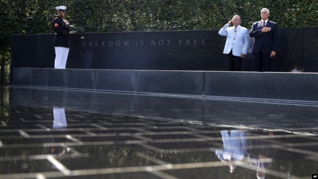 El vicepresidente de EE.UU. Mike Pence y el coronel del ejército retirado Richard Dean, vicepresidente de la Fundación Korean War Veterans, rinden honor a una bandera usada en una ceremonia conmemorativa por el retorno de restos de soldados de la Guerra de Corea. Washington, 20 de septiembre de 2018.