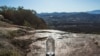 Voluntarios de la organización sin fines de lucro Border Angels dejan agua en un área remota de las montañas cerca del final de la cerca en la frontera entre Estados Unidos y México, en Tecate, California, el 29 de diciembre de 2018.