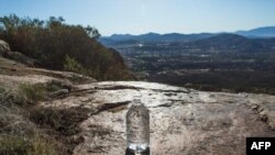 Voluntarios de la organización sin fines de lucro Border Angels dejan agua en un área remota de las montañas cerca del final de la cerca en la frontera entre Estados Unidos y México, en Tecate, California, el 29 de diciembre de 2018.