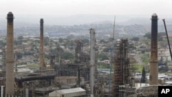 Chimneys from the Engen oil company are seen on the outskirts of the city of Durban, South Africa, Wednesday, Nov. 30, 2011. The U.N.'s top climate scientist cautioned climate negotiators Wednesday global warming is leading to human dangers and soaring fi