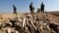 FILE - Bones, suspected to belong to members of Iraq's Yazidi community, are seen in a mass grave on the outskirts of the town of Sinjar, November 30, 2015. 