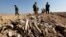 FILE - Bones, suspected to belong to members of  Iraq's Yazidi community, are seen in a mass grave on the outskirts of the town of Sinjar, Nov. 30, 2015.  