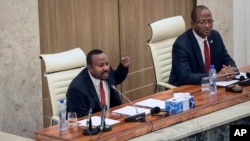 Ethiopia's Prime Minister Abiy Ahmed, left, addresses the parliament in the capital Addis Ababa, Ethiopia Nov. 15, 2022. 