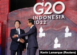 Perdana Menteri Jepang Fumio Kishida menyapa Presiden Joko Widodo saat tiba di KTT para pemimpin G20 di Nusa Dua, Bali, 15 November 2022. (Foto: REUTERS/Kevin Lamarque)